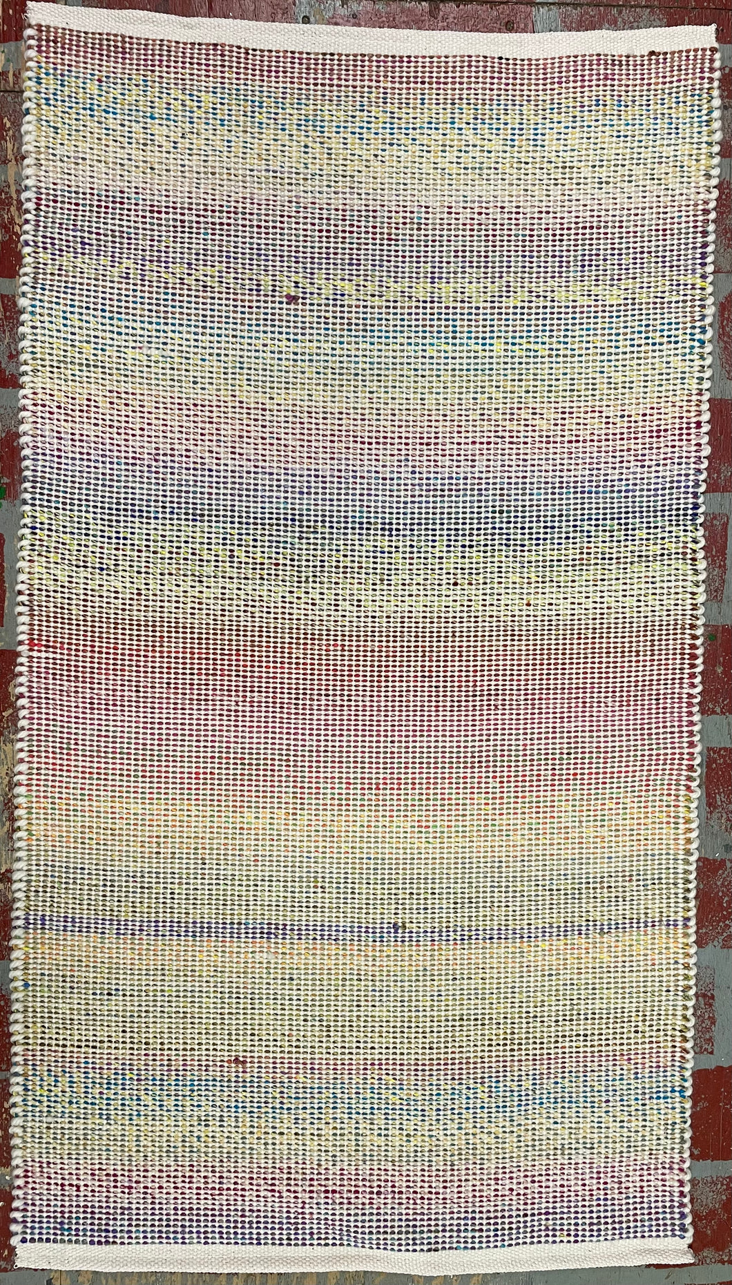 Multicolored Noro and cream colored yarns; 27” x 48”