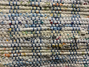 24” x 39” a white rug with specks of color, blue and white warp