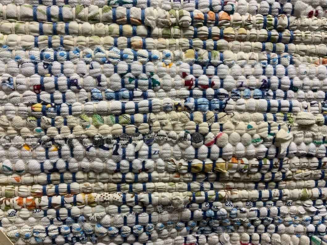 24” x 39” a white rug with specks of color, blue and white warp