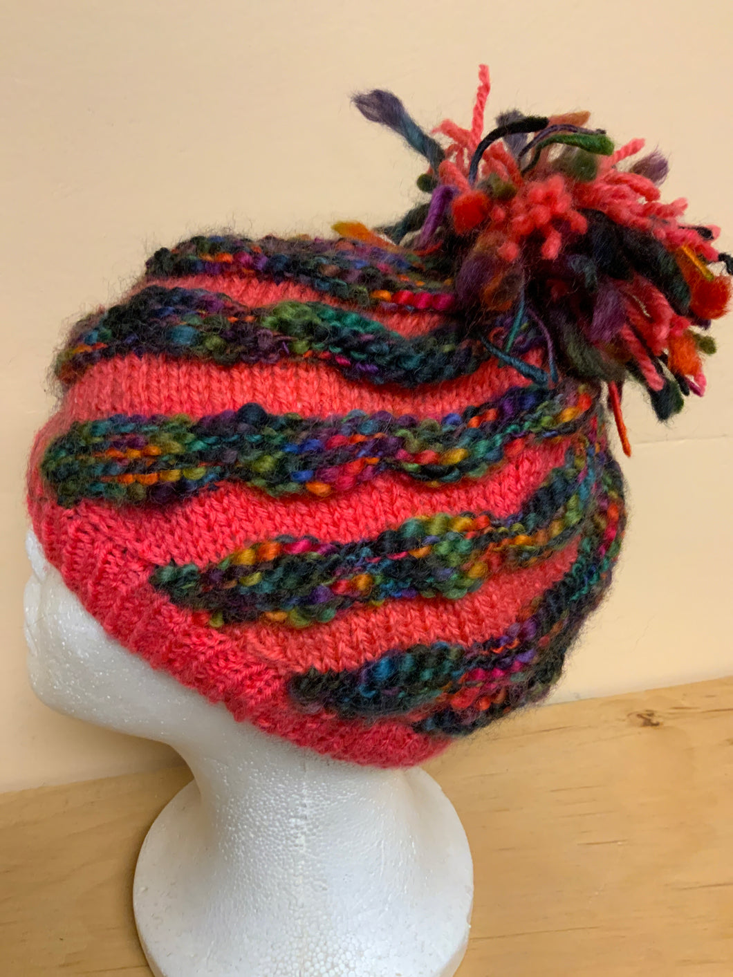 Hand-knit hat, pink with dark knit stripes, and Pom Pom on top