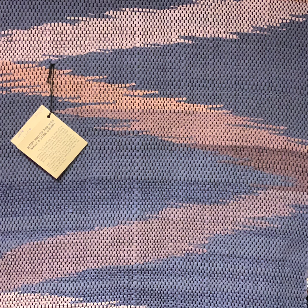 Blue background with peach/purple wave; 27” x 44” rag rug