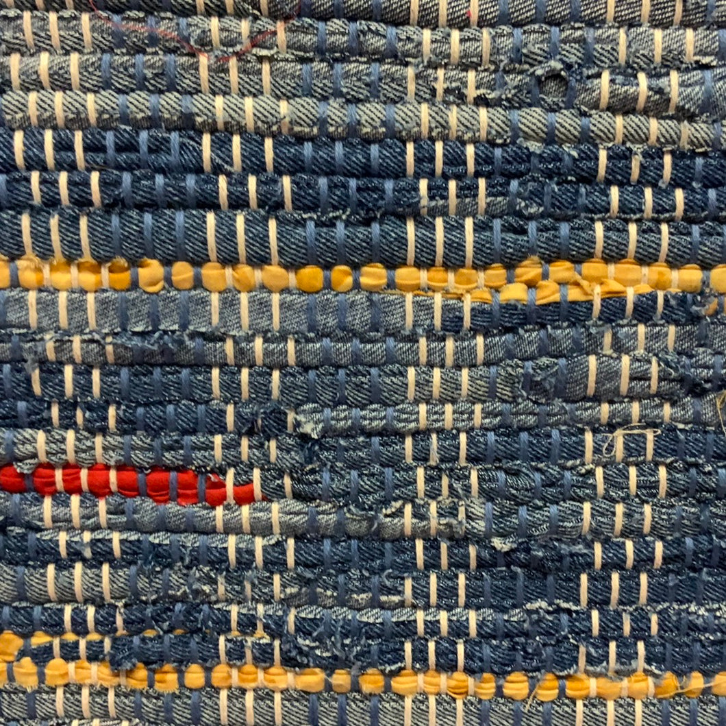 All denim with red and yellow highlights. 24” x 39”