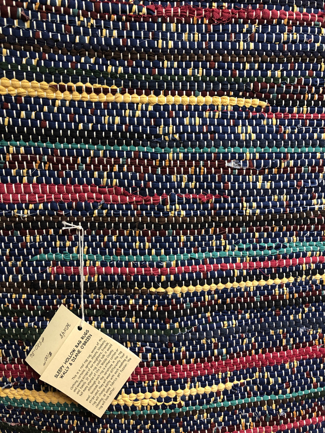 Navy blue with stripes of yellow and red 30” x 48” rug