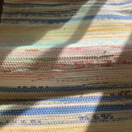 White rug with stripes of red, blue, yellow, and pink